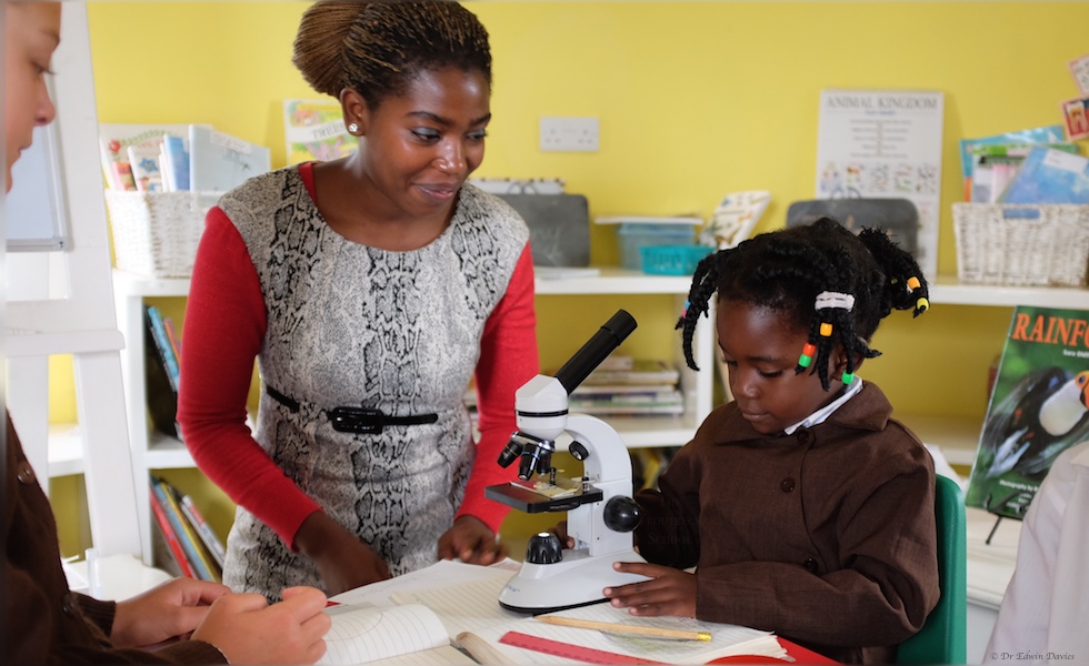 Five year old learning to use the microscope at The Troutbeck School